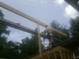 Carpenter setting a ridge beam over a new addition frame — Ice Dam Removal by Roofing Brothers in Pottsboro