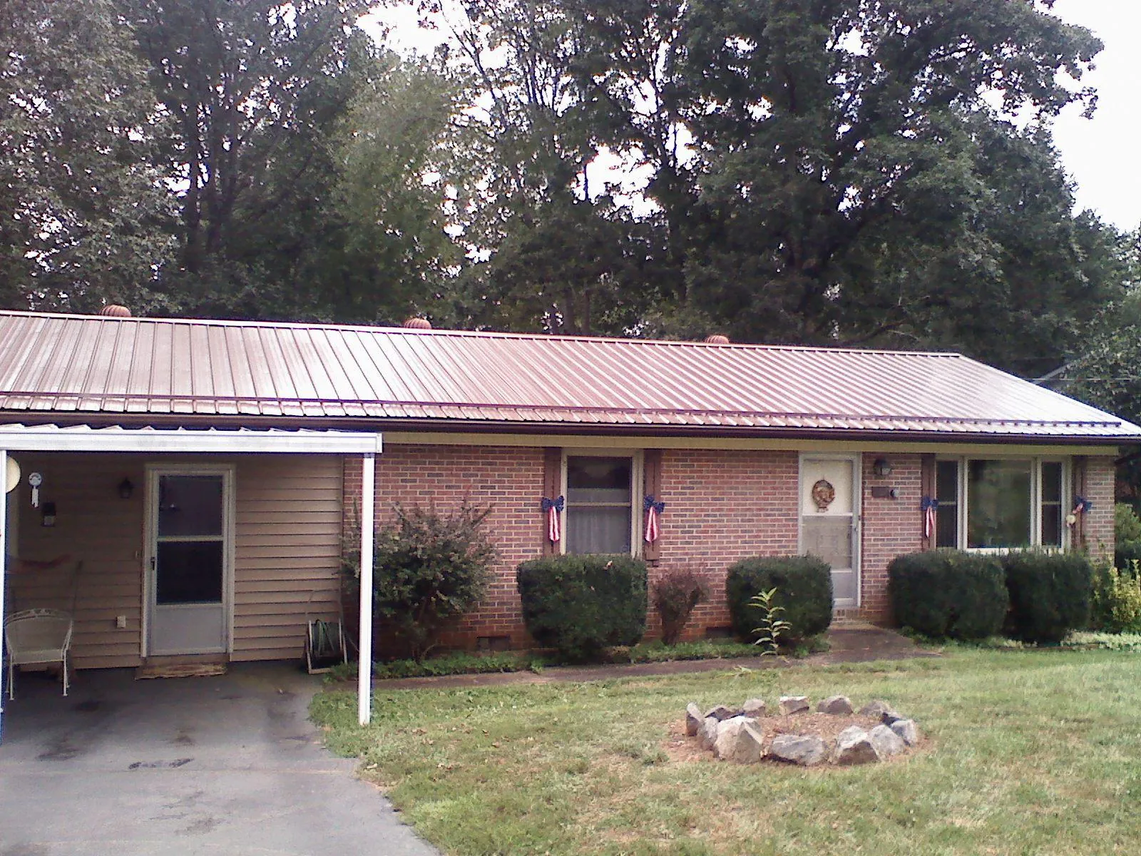 Bronze metal roof and carport on a brick ranch home — Roof Repair work by our crew in Pottsboro